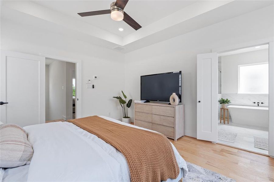 The spacious primary ensuite boasts a frameless shower, a stand-alone tub, and separate his-and-her sinks with dedicated vanity sections, exuding luxury and offering a personal sanctuary for relaxation and rejuvenation.