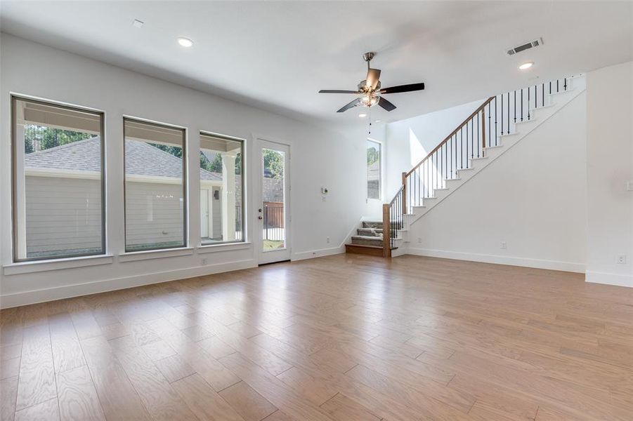 Unfurnished living room featuring ceiling fan, light hardwood / wood-style flooring, and plenty of natural light