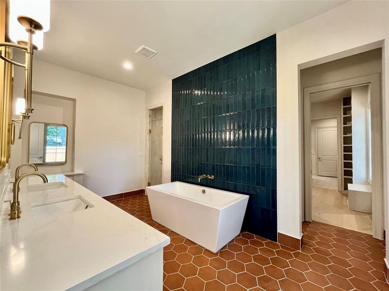 Bathroom featuring tile walls, vanity, a washtub, and tile patterned floors