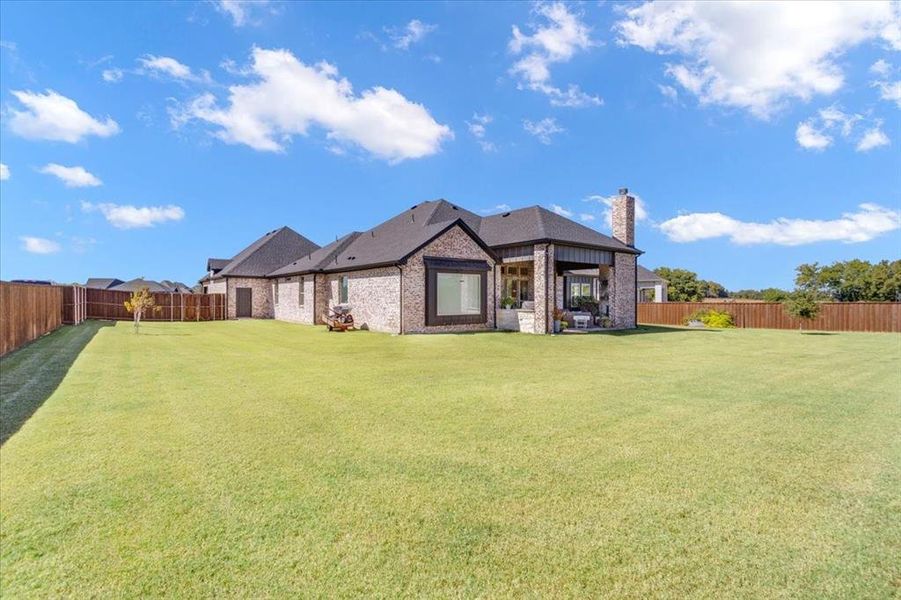 Back of house featuring a lawn and a patio