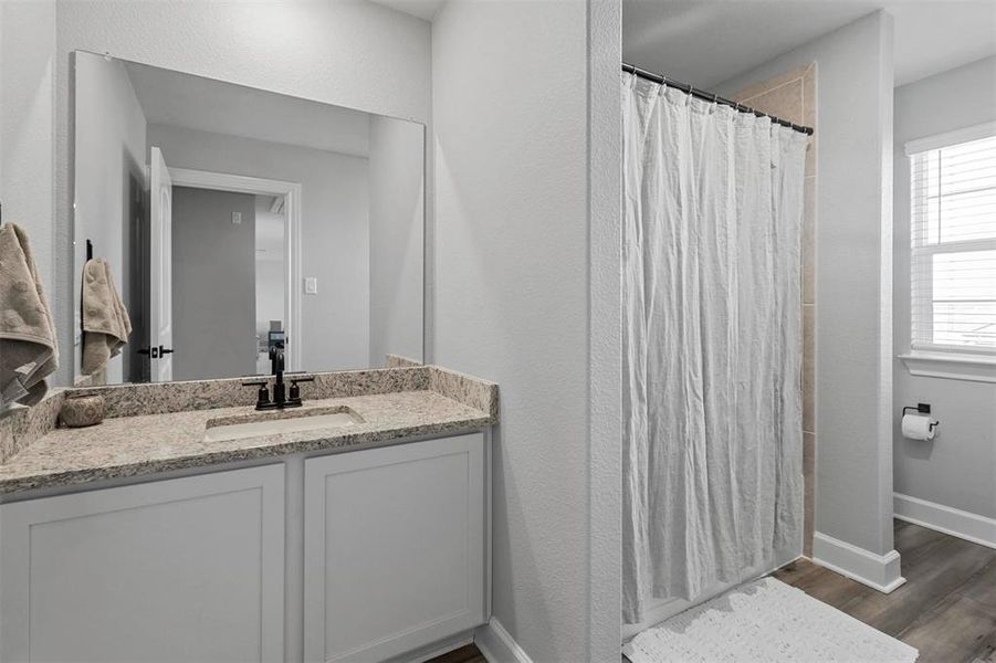 Bathroom with vanity, hardwood / wood-style floors, and a shower with curtain