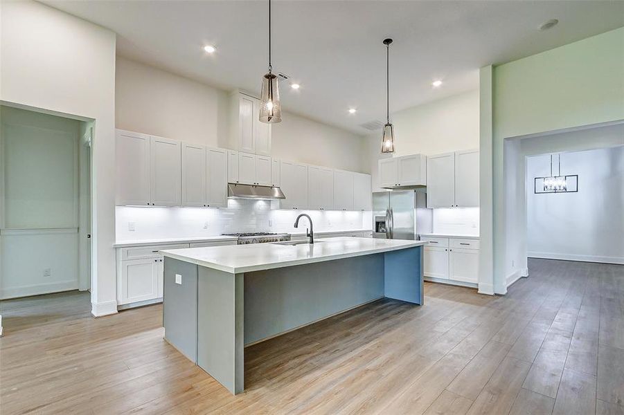 Your chef inspired kitchen awaits! Features include Quartz countertops paired with a coordinating tile backsplash, Stainless Steel appliances, a luxe gas range, upgraded cabinetry, disk lightings, and a spacious island with breakfast bar seating and pendent lights.