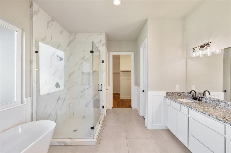 Stunning primary bathroom with double sinks, soaker tub, and separate shower