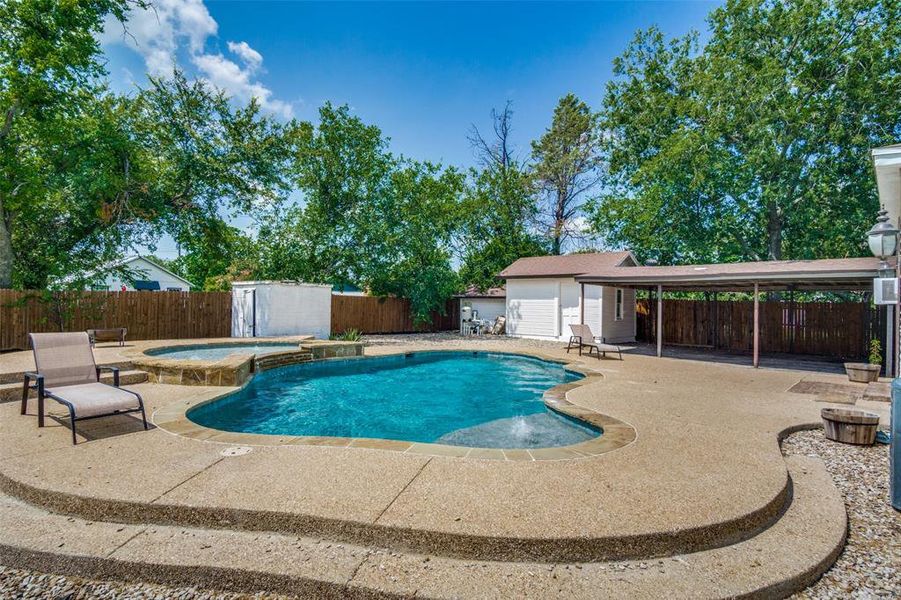 View of pool with an in ground hot tub, a patio, and a storage unit