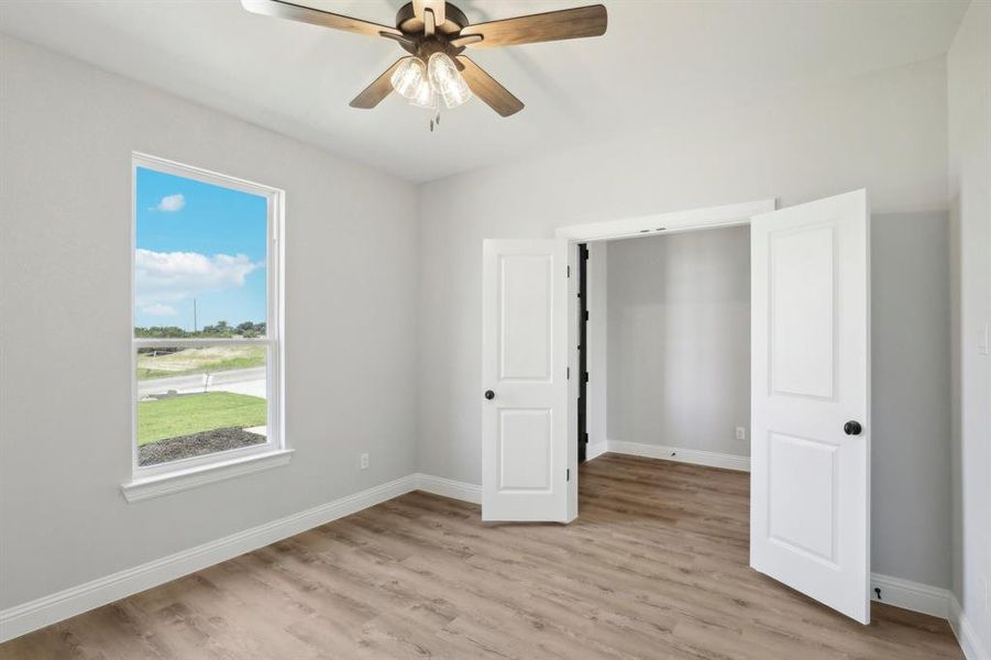 Unfurnished bedroom with ceiling fan and light hardwood / wood-style floors