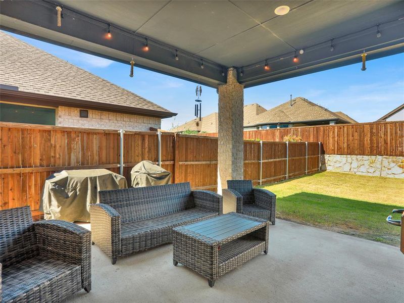 Rear view of house featuring a patio area and large grassy lawn.