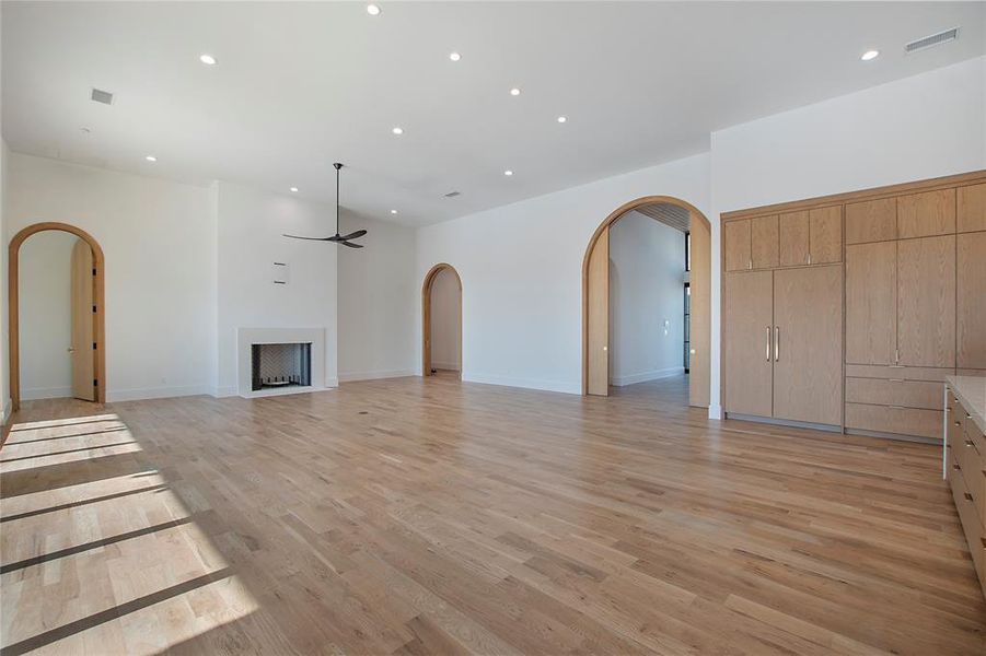 Unfurnished living room with ceiling fan and light hardwood / wood-style floors