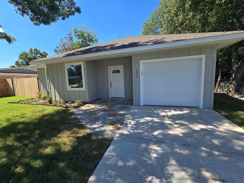 Ranch-style house with a front yard and a garage