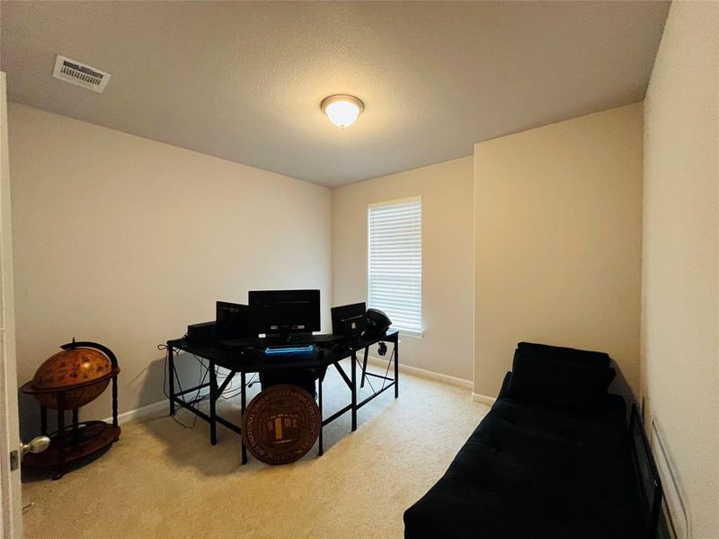 Home office with light carpet and a textured ceiling