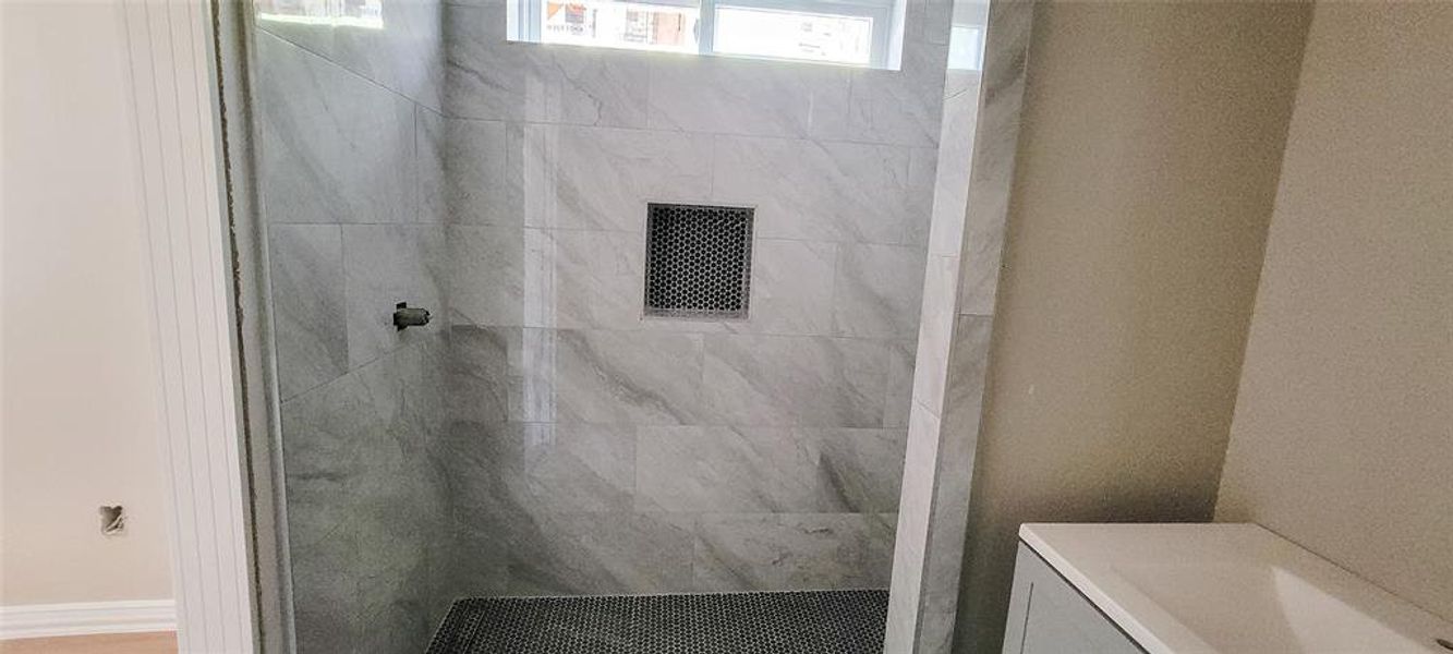 Bathroom featuring vanity and a tile shower