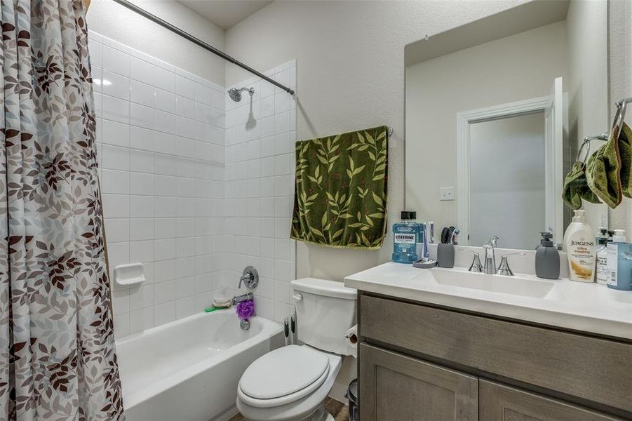 Full bathroom featuring vanity, shower / tub combo, and toilet