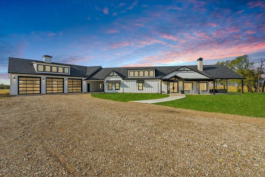 View of front facade featuring a lawn and a garage