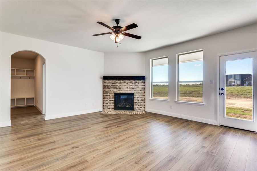 Unfurnished living room with light wood-type flooring, a fireplace, and plenty of natural light