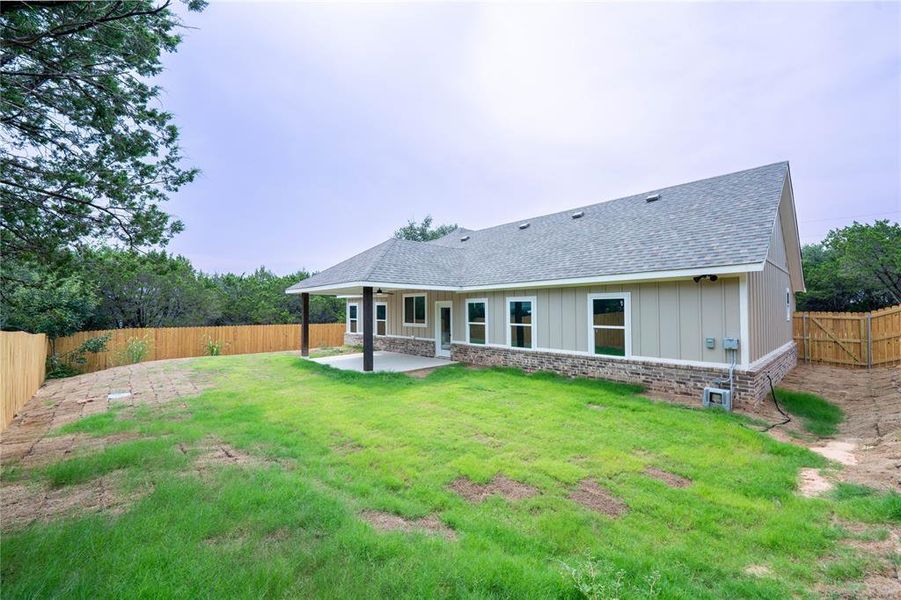 Rear view of property with a yard and a patio area