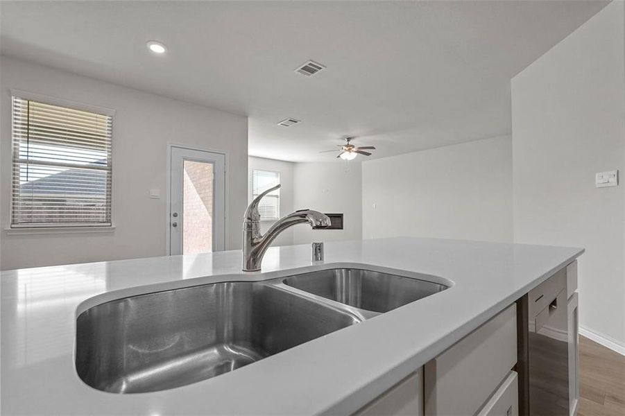 Kitchen featuring hardwood / wood-style floors, sink, and ceiling fan