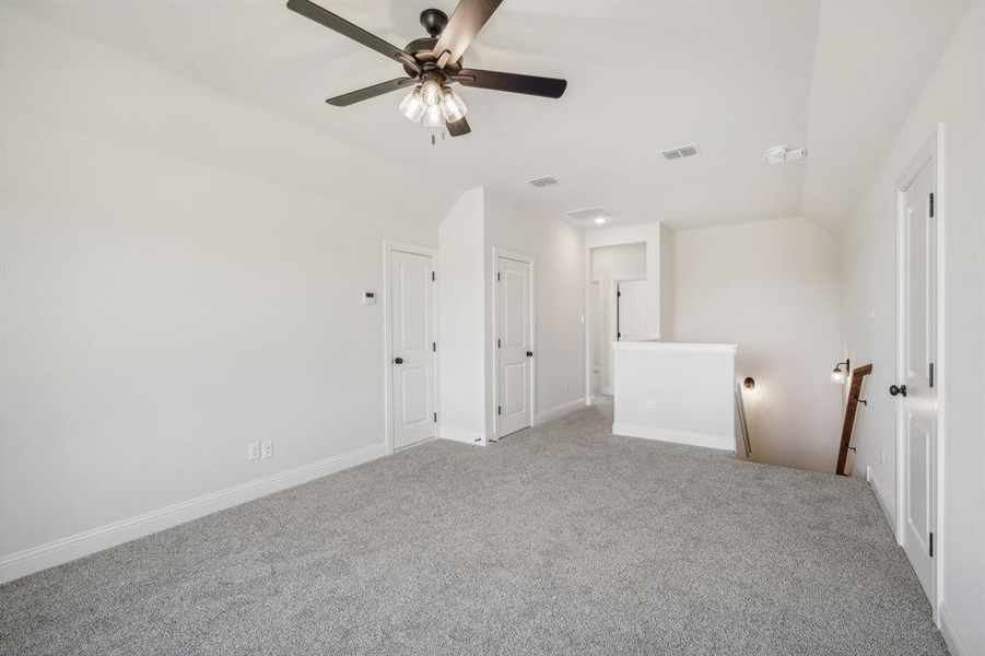Unfurnished room with vaulted ceiling, carpet floors, and ceiling fan