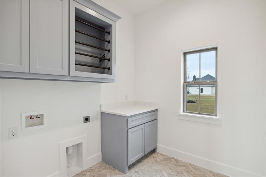 Laundry room with cabinets, washer hookup, hookup for an electric dryer, and light parquet flooring