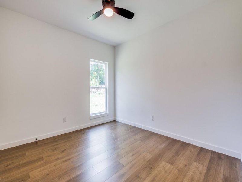 Unfurnished room with wood-type flooring and ceiling fan