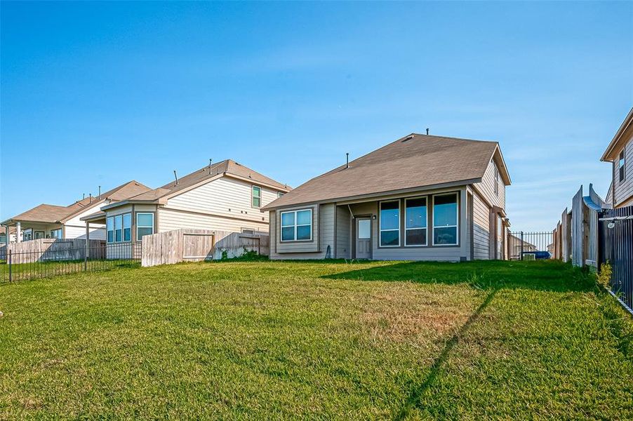 The backyard features a lovely covered patio, providing a shaded oasis for outdoor entertaining or relaxing. With ample space for furniture, it's perfect for alfresco dining or enjoying a cozy evening by the fire.