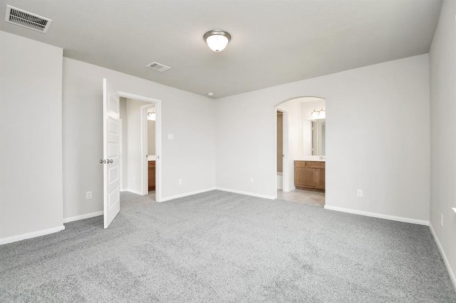 Secondary bedroom features plush carpet and an en-suite bathroom.