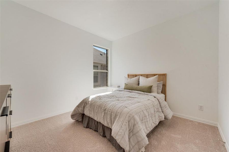 Bedroom with light carpet and vaulted ceiling