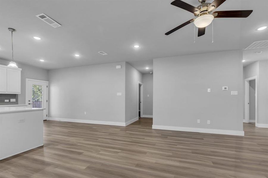 Unfurnished living room with light hardwood / wood-style floors and ceiling fan