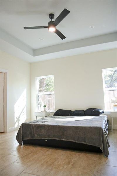 Tiled bedroom featuring ceiling fan