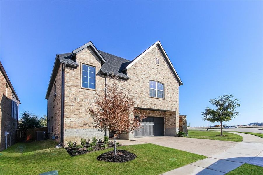 View of front of property with a garage, cooling unit, and a front yard