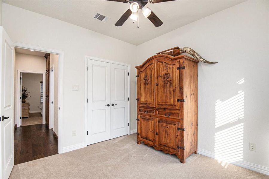 Bedroom featuring a closet, ceiling fan, and light carpet