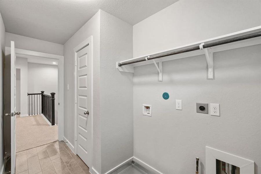 A perfect blend of functionality and comfort. Laundry room, thoughtfully equipped with shelving for effortless organization. Both gas and electric connections available. Sample photo of completed home with similar floor plan. As-built interior colors and selections may vary.