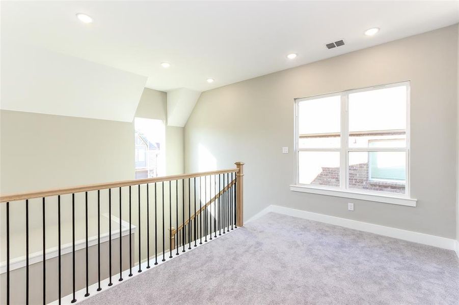 Corridor with carpet floors and lofted ceiling