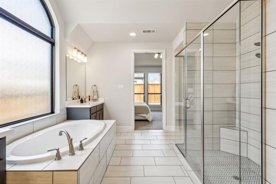 Bathroom with shower with separate bathtub, tile patterned flooring, and vanity