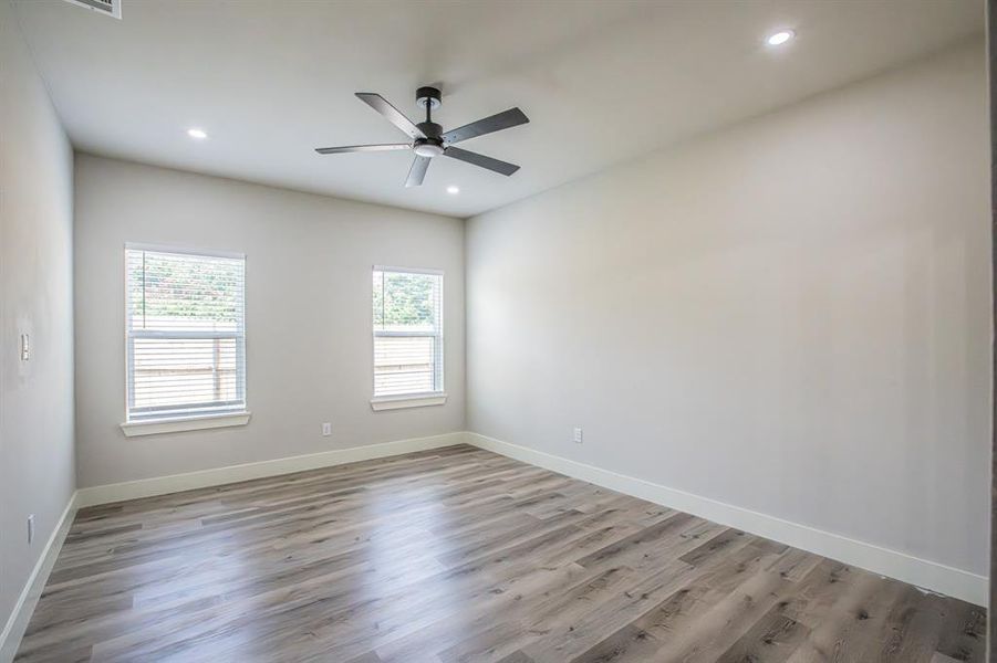 Unfurnished primary room featuring ceiling fan and hardwood / wood-style flooring