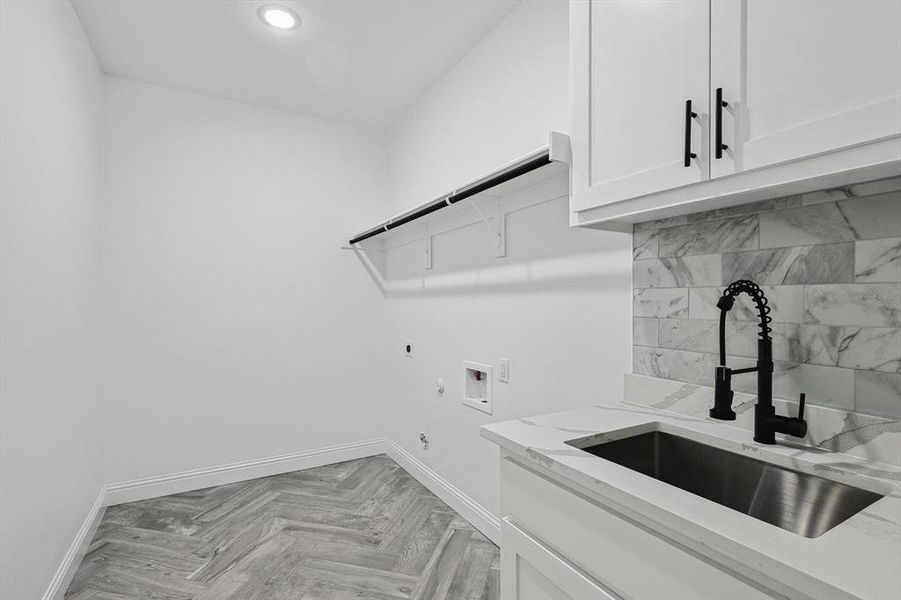 Laundry room with hookup for a washing machine, sink, electric dryer hookup, gas dryer hookup, and cabinets