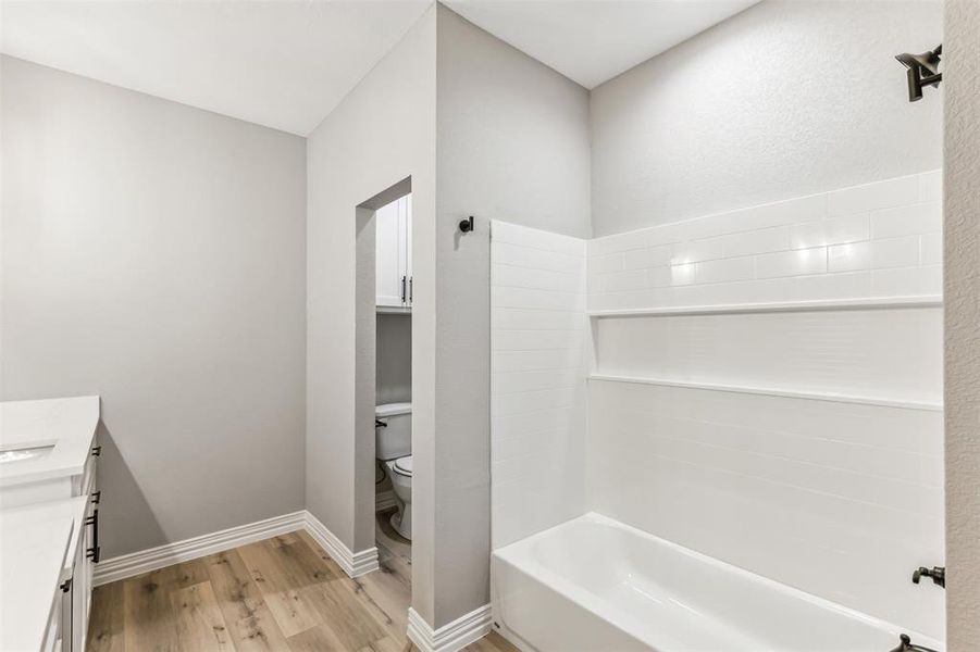 Bathroom featuring vanity, toilet, and hardwood / wood-style floors