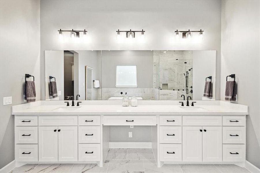 Quartz countertop with dual sinks and vanity area.