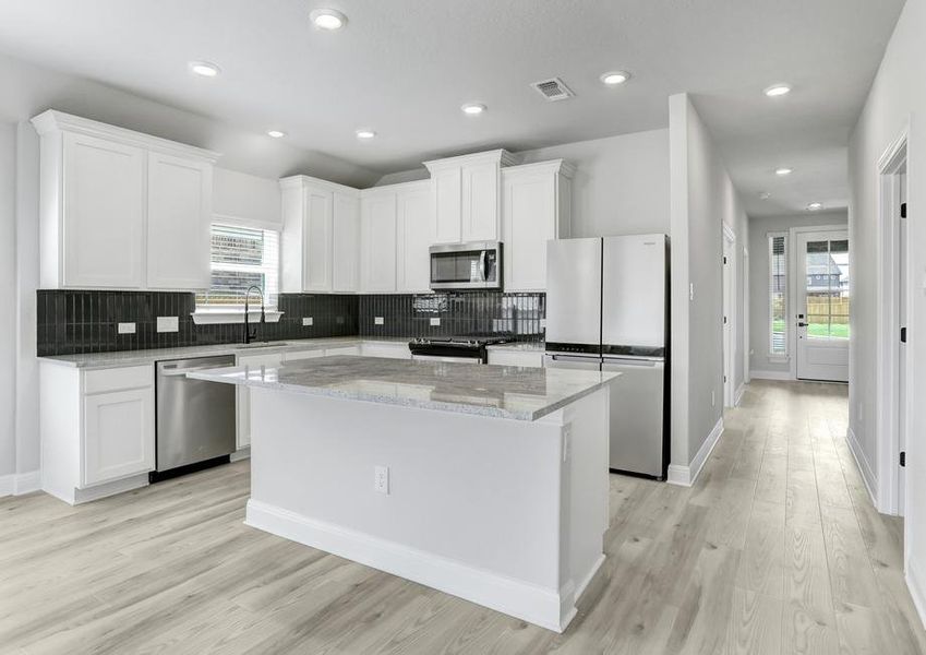 Gorgeous upgraded kitchen with granite countertops, stainless appliances, and wood-style flooring.