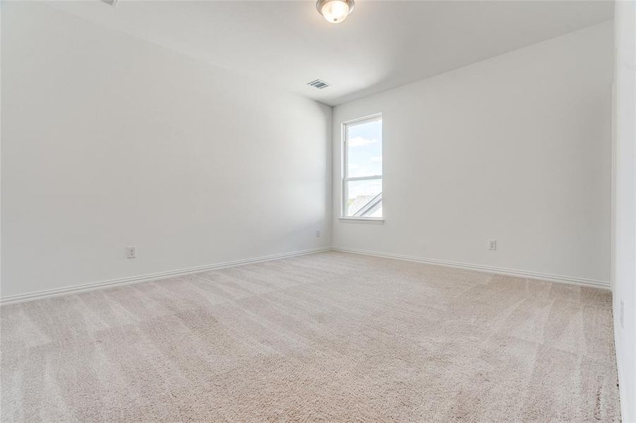 Empty room featuring light carpet