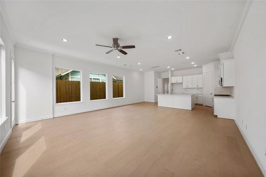 A large space for entertainment and relaxation, this Living Area boasts wood flooring and large windows, with an abundance of natural light. The space opens to the kitchen and dining area, creating the perfect open-concept layout. (Sample photos of a completed Gibraltar floor plan. The image may feature alternative selections and/or upgrades.)