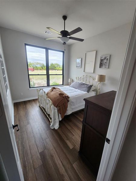 Bedroom with dark hardwood / wood-style flooring and ceiling fan