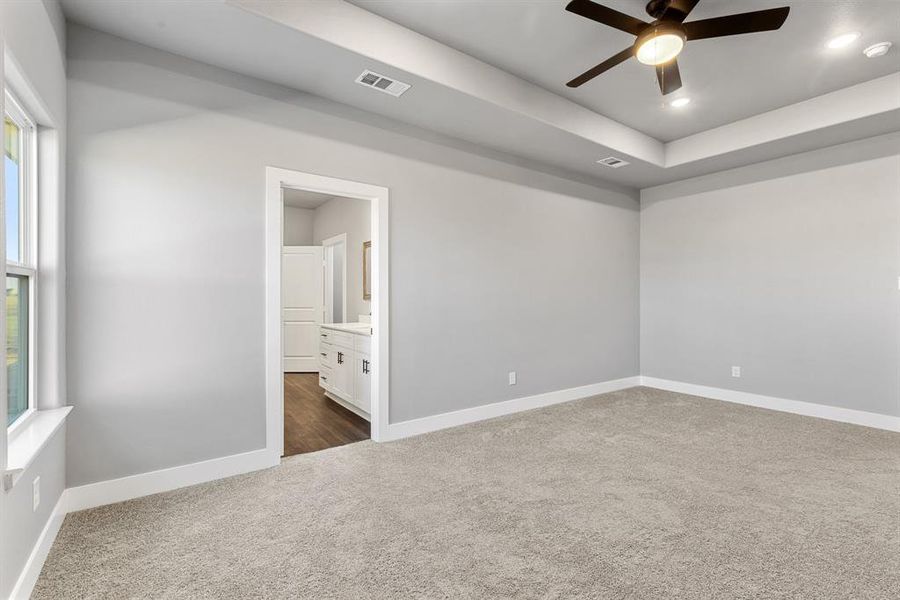 Spare room with dark colored carpet and ceiling fan