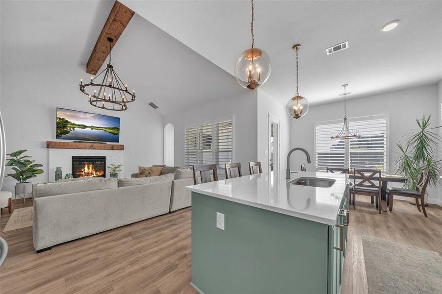 Kitchen featuring plenty of natural light, a center island with sink, sink, and light hardwood / wood-style flooring