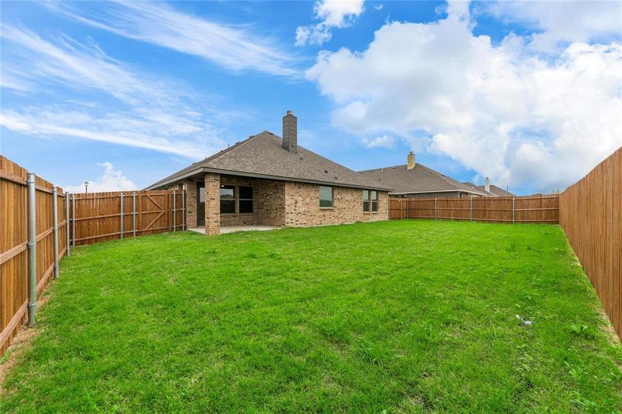 Back of property featuring a patio and a yard