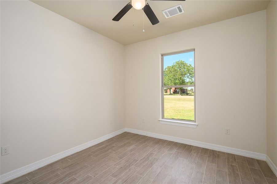 Spare room featuring light hardwood / wood-style flooring, a wealth of natural light, and ceiling fan