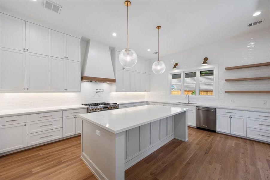 Large chef's kitchen with pro 48" gas range and 48" built in fridge and windows overlooking backyard