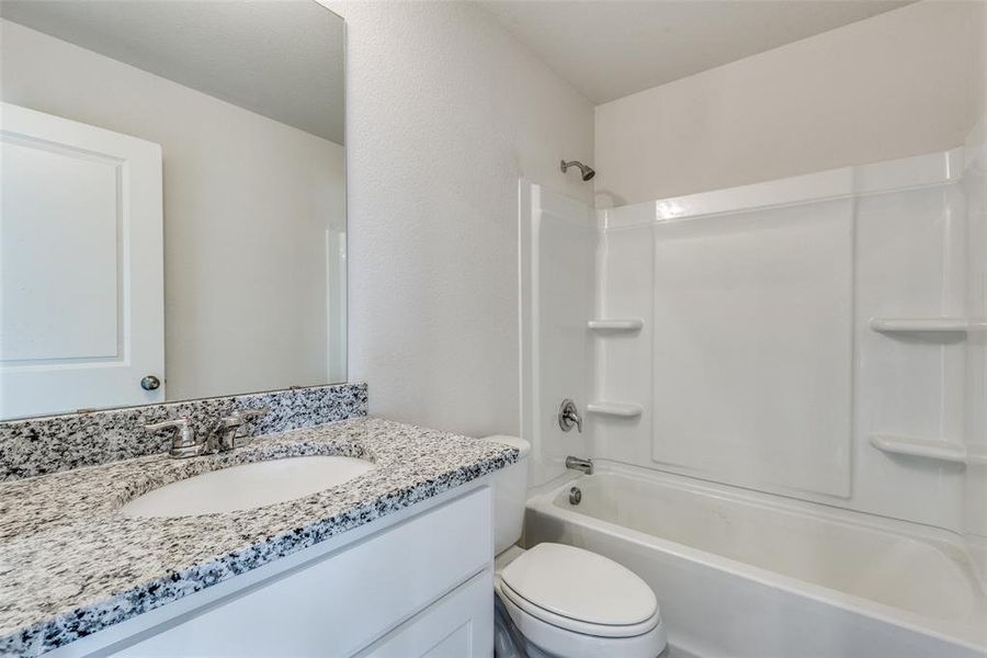 Full bathroom featuring shower / tub combination, vanity, and toilet