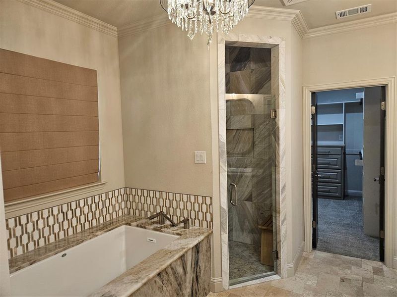 Bathroom featuring a chandelier, crown molding, and separate shower and tub