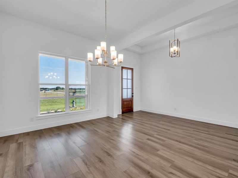 Unfurnished dining area with a chandelier and hardwood / wood-style flooring