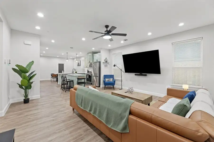 Living room with light hardwood / wood-style floors and ceiling fan