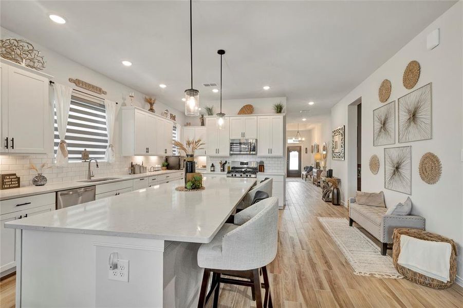 Open Concept Layout - Extra seating space on the right, long island on the left, and a view of the front door in the distance, showcasing the home's open layout.